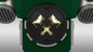 A close-up of the V.10 Fire Lizards Backpack Cover Detail V.1—a circular black emblem featuring two gold gavels crossed at the center, set against a green and metallic background with vent-like accents on each side—available as a 3D print digital file for customizing your Galactic Warriors backpack.