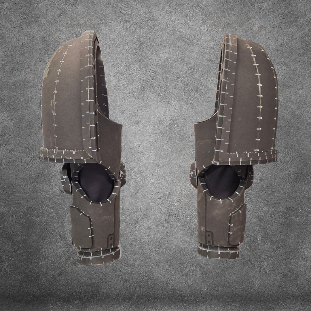 Two identical, futuristic dark gray armored helmets with large visors and white stitching details—perfect for Galactic Warriors cosplay—are displayed side by side against a textured gray background. The V.10 Tactical Arms Pattern is ideal as a digital download EVA foam template for your next costume project.