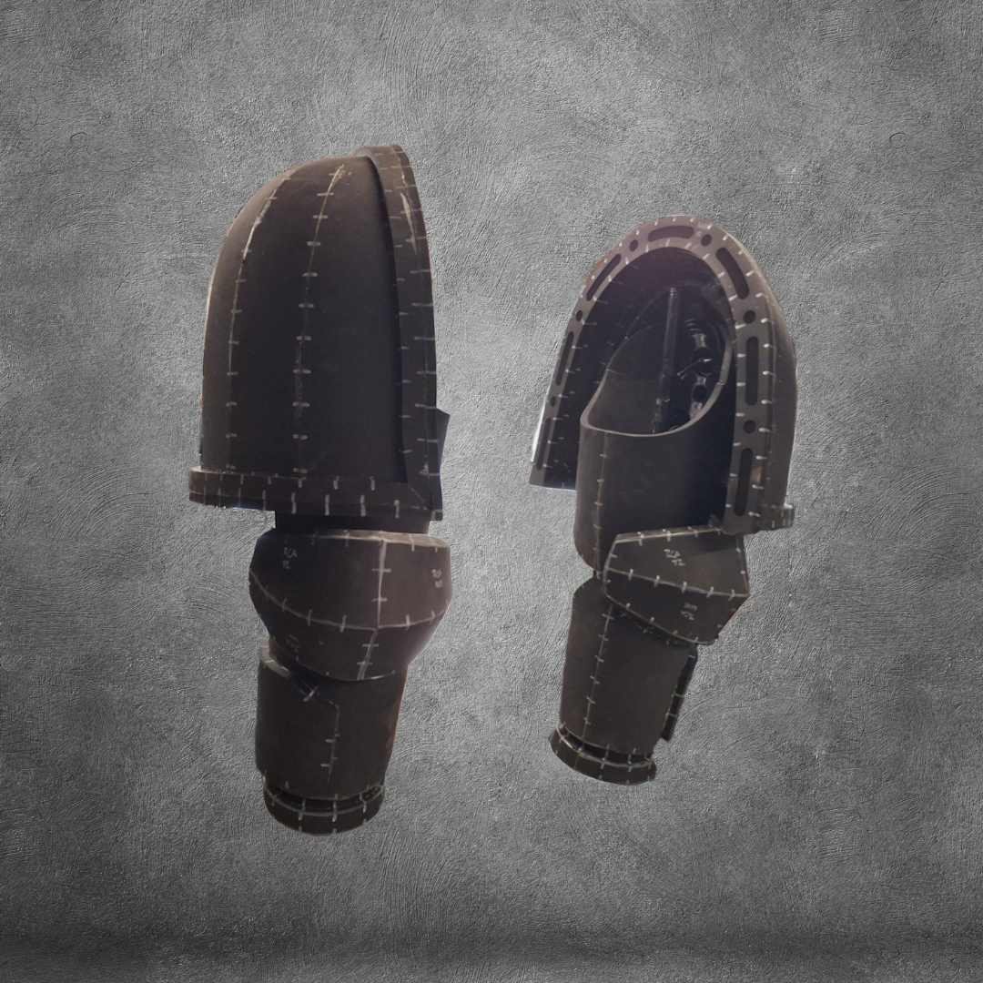 Displayed against a textured gray background, the V.10 Tactical Arms Pattern features two black, segmented armor pieces with visible stitching and metallic accents. Reminiscent of Galactic Warriors’ arm or shoulder guards, this impressive EVA foam template is offered as a digital download—perfect for elevating your next cosplay project.