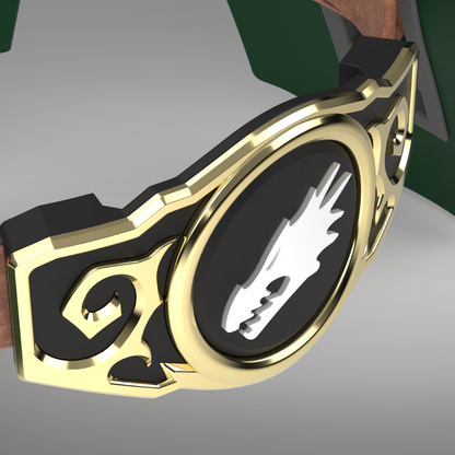 A close-up of a decorative belt buckle or watch strap component with a gold-tone frame, black insert, and a white stylized emblem on a gray background.