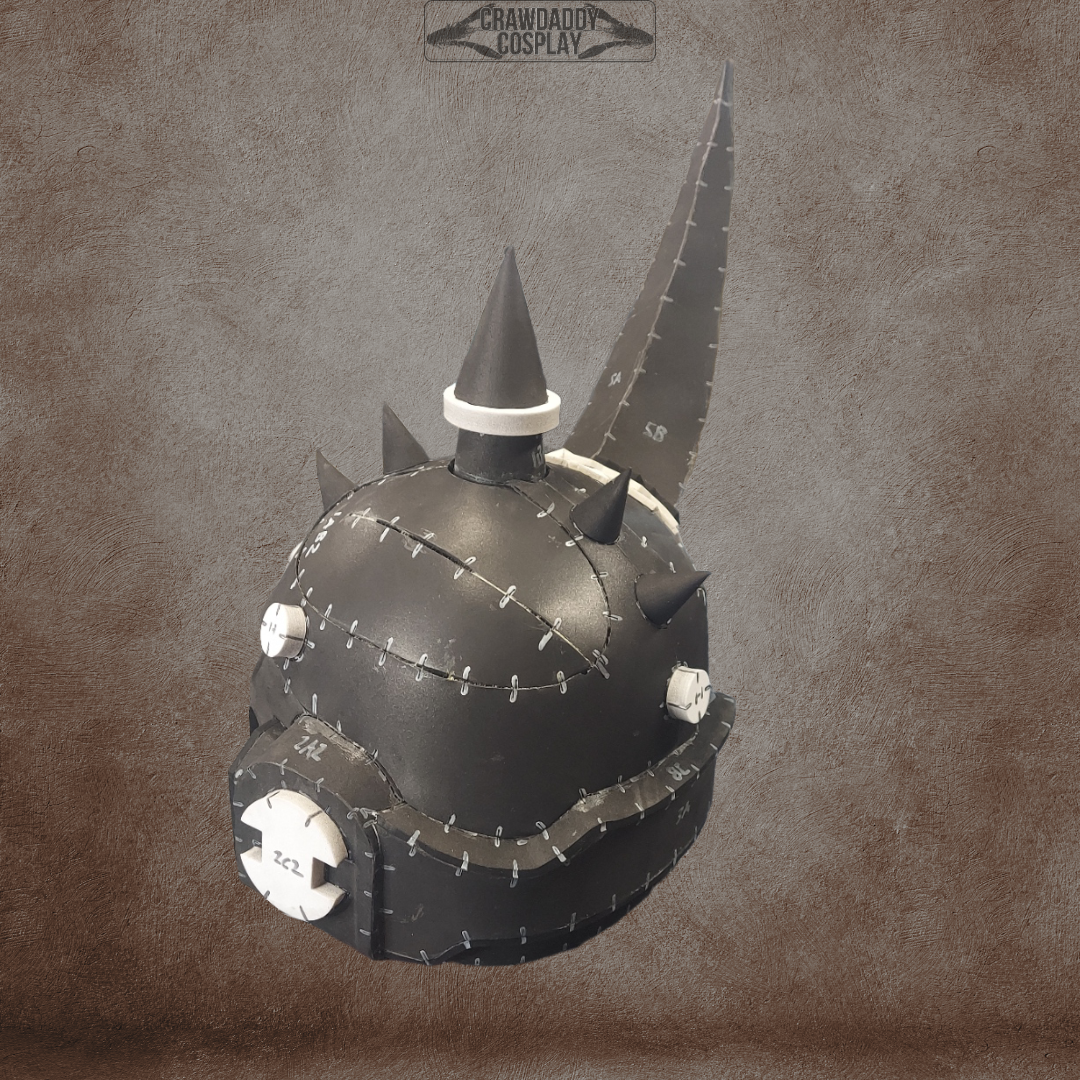 A black, steampunk-inspired Mortis Sentry Helmet with prominent white details, large stitched seams, and spiked accents—including a tall pointed horn and circular metal plates—set against a brown textured background. Perfect as an EVA foam helmet template, this digital download offers a unique design for costume or cosplay creation.