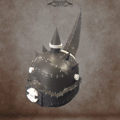 A black, steampunk-inspired Mortis Sentry Helmet with prominent white details, large stitched seams, and spiked accents—including a tall pointed horn and circular metal plates—set against a brown textured background. Perfect as an EVA foam helmet template, this digital download offers a unique design for costume or cosplay creation.