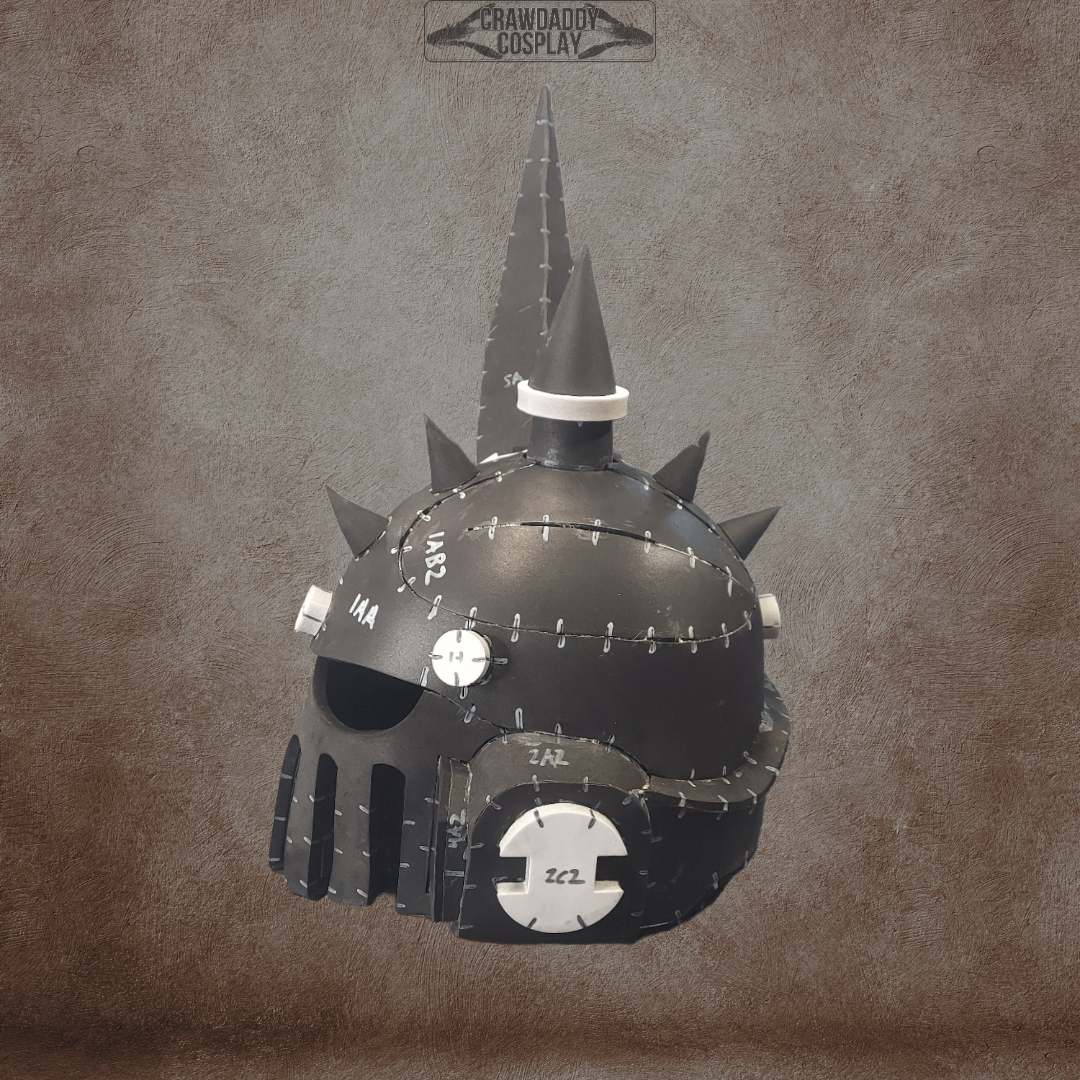 The Mortis Sentry Helmet, featuring a black, spiked, and riveted fantasy or sci-fi-inspired design with a grated mouthpiece and detailed metal accents—ideal for cosplay enthusiasts—is displayed against a textured brown background. Offered as an EVA foam helmet template digital download.
