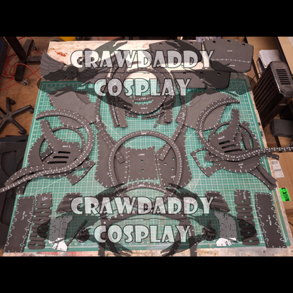 Cosplay costume parts on a cutting mat with 'Crawdaddy Cosplay' branding.