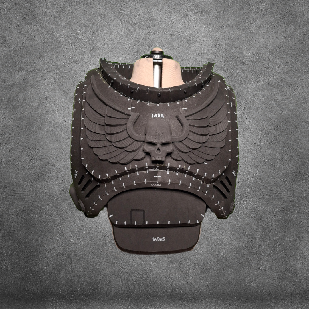 Showcased on a torso mannequin against a gray textured backdrop, the V.10 Tactical Chest Pattern features black, foam-crafted Galactic Warriors armor adorned with a bold winged skull emblem. White stitching lines highlight the design details, and you can recreate this impressive look using the digital download EVA foam template.