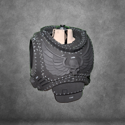 A detailed, black, sci-fi inspired V.10 Tactical Chest Pattern featuring a winged skull emblem is displayed on a mannequin torso against a textured gray background. Crafted using an EVA foam template, this design is available as a convenient digital download.