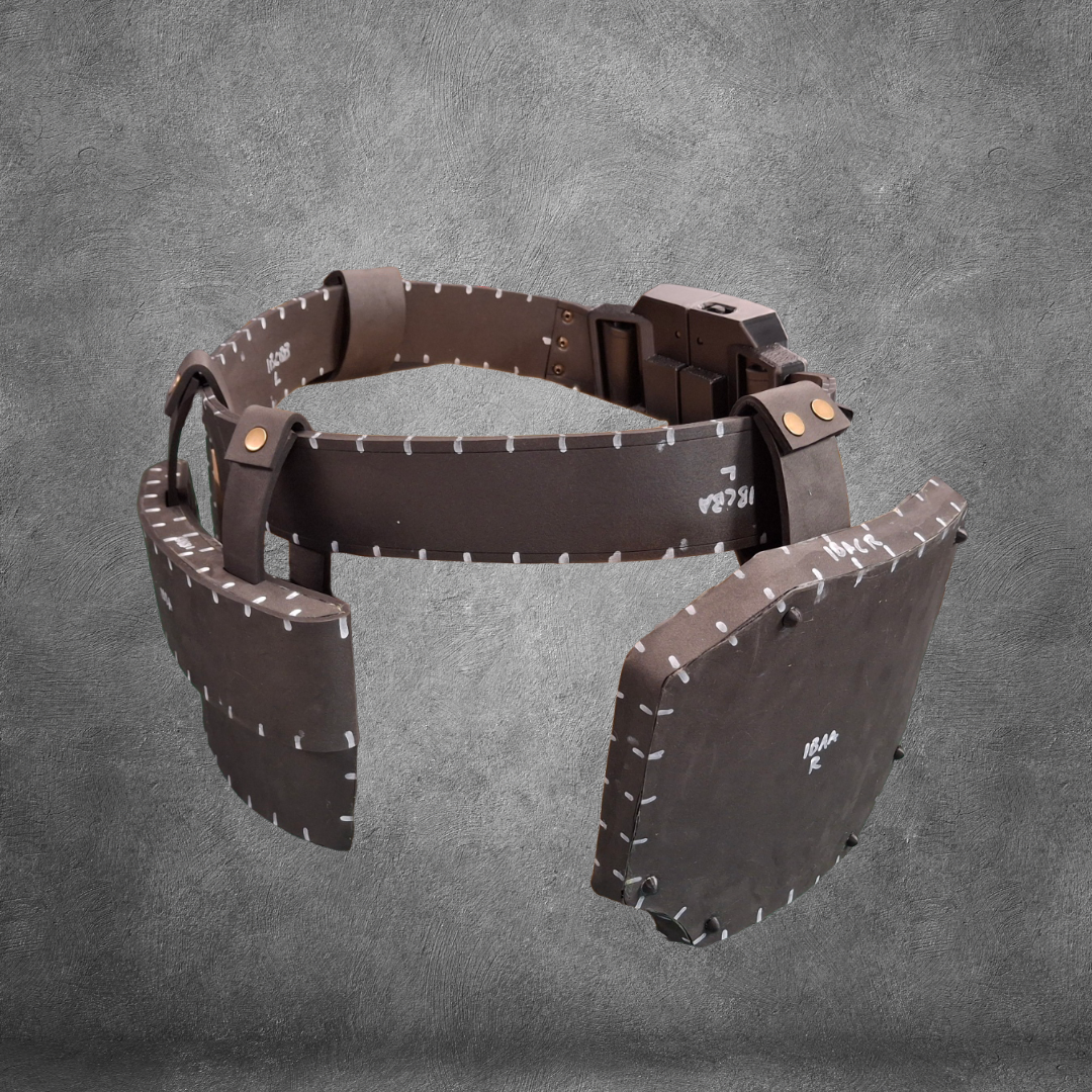 Introducing the V.10 Tactical Waist Pattern: a digital EVA foam template featuring large, rectangular padded panels with visible white stitching for a brown leather-like look, perfect as a Galactic Warriors Waist accessory. Instantly download this convenient pattern and start crafting your next cosplay, all displayed on a sleek gray textured background.