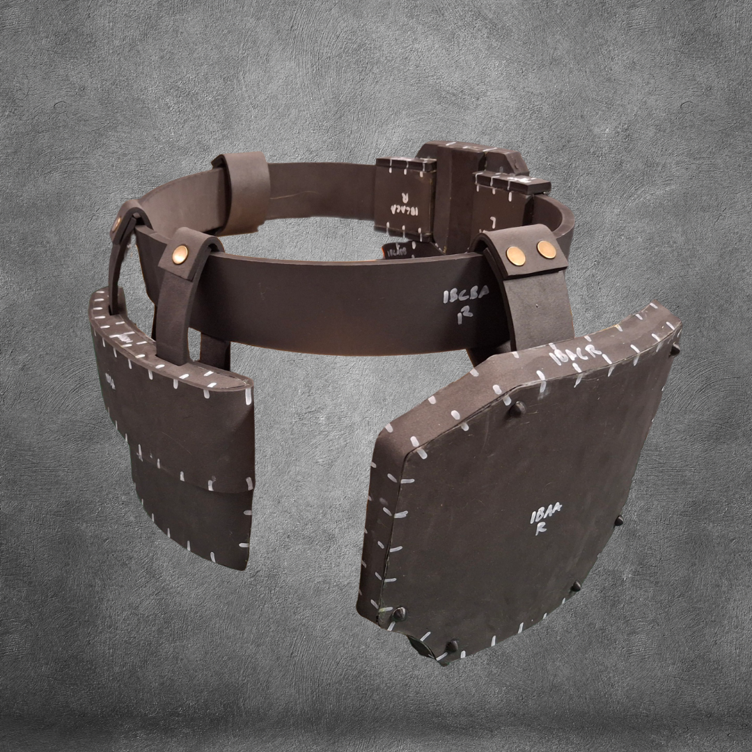 The V.10 Tactical Waist Pattern, a digital download for creating a brown, medieval-style leather belt with large square armor plates—ideal for Galactic Warriors Waist cosplay—is displayed against a textured gray background. This high-quality template is crafted from EVA foam for authentic results.